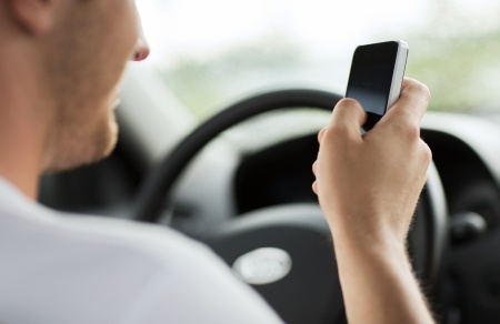 distracted man using cell phone to text while driving Queener Law