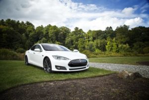 white tesla sports car on display on golf course setting Queener Law