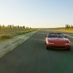 red sports car driving on open road Queener Law