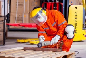 construction worker using drill with proper PPE Queener Law