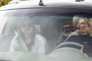 two women in car drinking beer while driving Queener Law