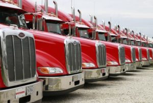 long row of red semi trucks ready to roll Queener Law